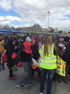 Een vrijwilliger van Solidariteit Piraeus deelt maandverband en luiers uit