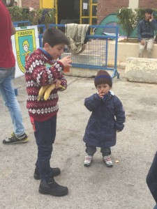 Een jongetje uit SyriÃ« slurpt hete thee terwijl zijn broertje toekijkt